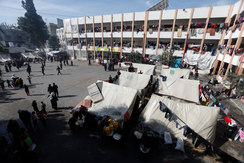 Palestinos desplazados se reúnen en una escuela que acoge a personas que huyeron de sus casas debido a los ataques israelíes, en Rafah, en el sur de la Franja de Gaza