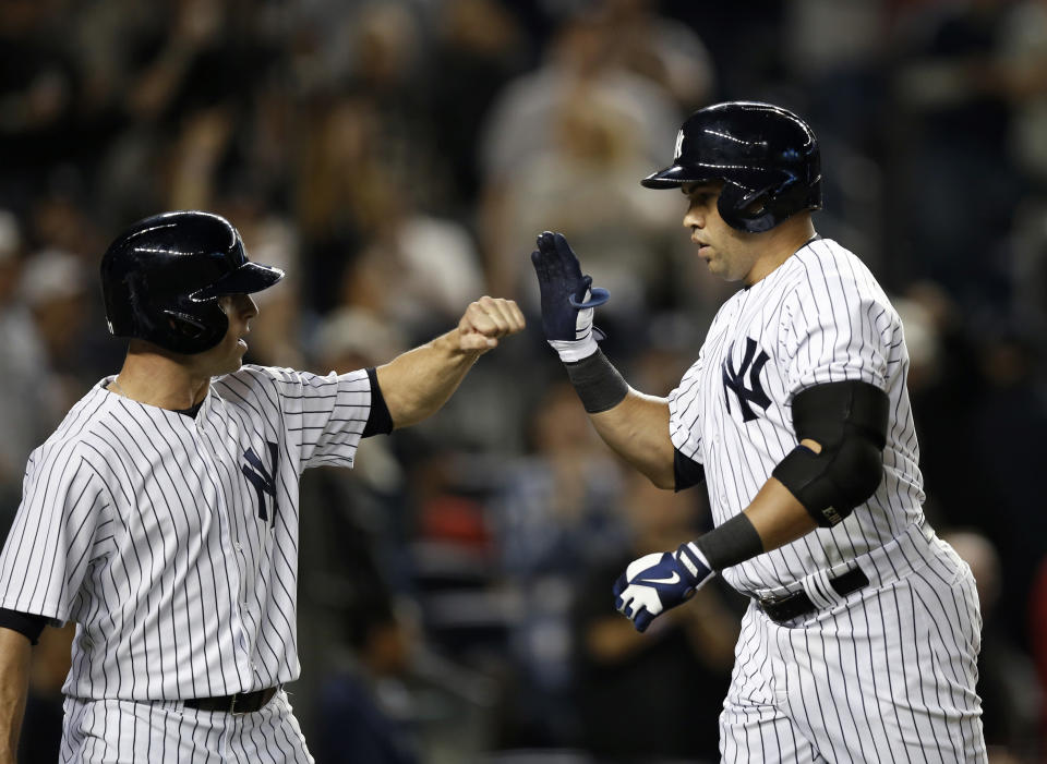 New York Yankees Brett Gardner congratulates New York Yankees Carlos Beltran after scoring on Beltran's third-inning, two-run home run in the MLB American League baseball game against the Boston Red Sox at Yankee Stadium in New York, Sunday, April 13, 2014. (AP Photo/Kathy Willens)