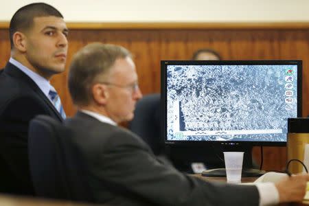Former New England Patriots football player Aaron Hernandez (L) sits with his defense attorney Charles Rankin as a photograph of tire marks is displayed on a monitor during his murder trial at the Bristol County Superior Court in Fall River, Massachusetts, March 5, 2015. REUTERS/Steven Senne/Pool