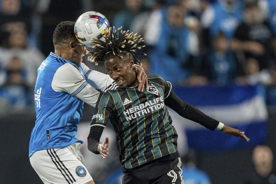 Charlotte FC defender Jaylin Lindsey, left, and LA Galaxy forward Kevin Cabral (9) jump for a head ball during the first half of an MLS soccer match in Charlotte, N.C., Saturday, March 5, 2022. (AP Photo/Jacob Kupferman)