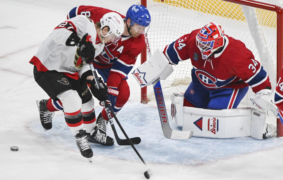 Ottawa Senators' Parker Kelly (27) moves in on Montreal Canadiens goaltender Jake Allen as Canadiens' Mike Matheson (8) defends during the first period of an NHL hockey game in Montreal, Tuesday, Jan. 23, 2024. (Graham Hughes/The Canadian Press via AP)