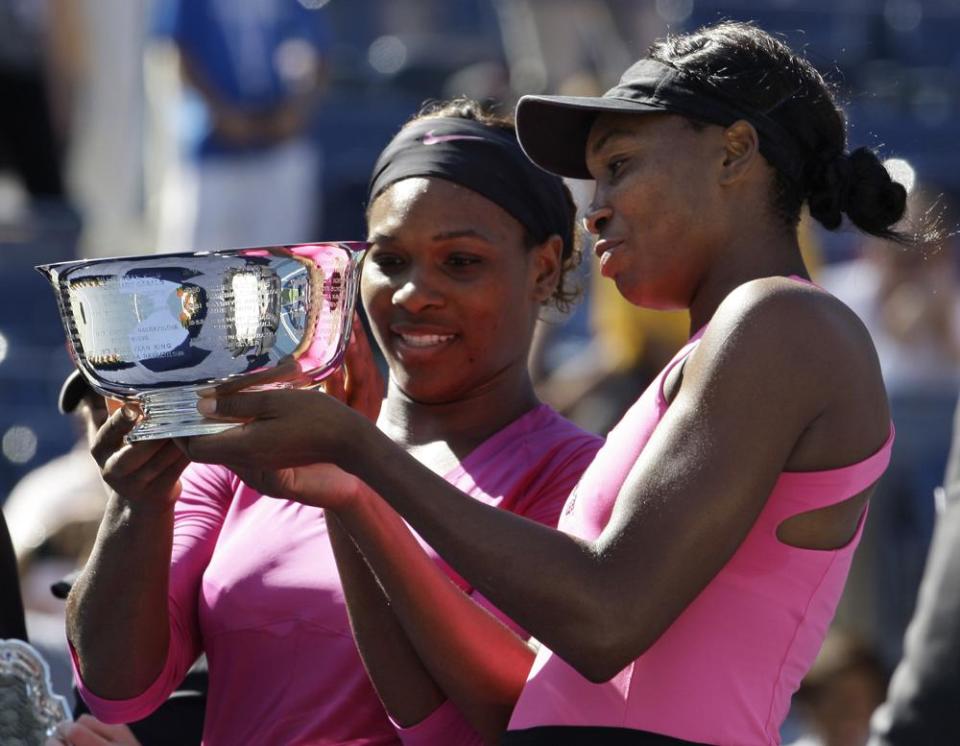 Serena Williams, left, of the United States, and her sister Venus examine the championship trophy after winning the women’s doubles championship over Cara Black, of Zimbabwe, and Liezel Huber, of the United States, at the U.S. Open tennis tournament in New York, Monday, Sept. 14, 2009. Serena and Venus Williams were given a wild-card entry for women’s doubles at the U.S. Open on Saturday, Aug. 27, 2022, making it their first tournament as a team in more than four years. (AP Photo/Darron Cummings, File)