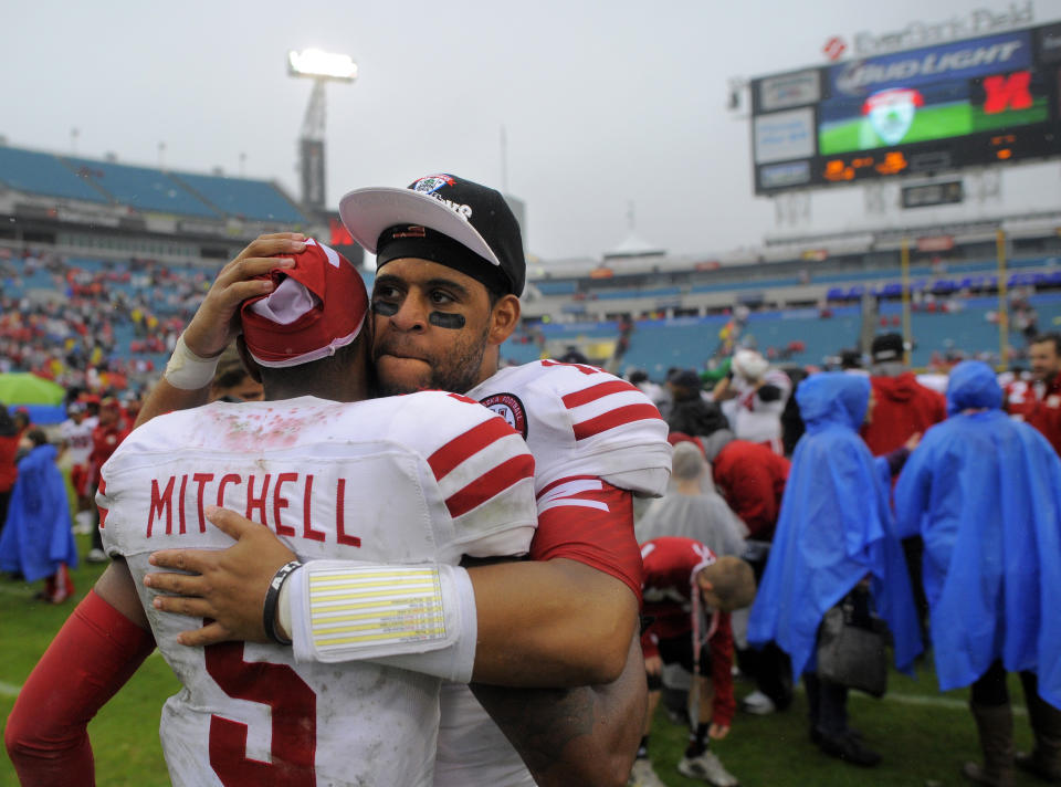 Nebraska quarterback Ron Kellogg III (12) hugs his teammate quarterback Johnny Stanton (5) after their 24-19 win in the Gator Bowl NCAA college football game against Georgia, Wednesday, Jan. 1, 2014, in Jacksonville, Fla. (AP Photo/Stephen B. Morton)