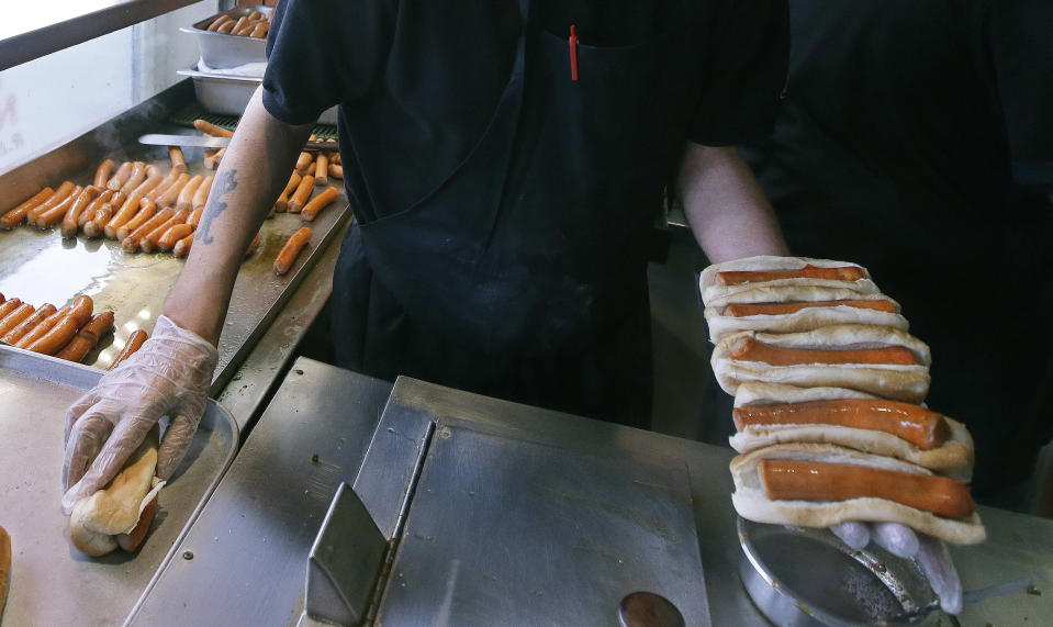 In this Monday, March 3, 2014 photo Sal O'Brien holds wieners he will prep for a customer's order at Olneyville New York System of Providence in Providence, R.I. The James Beard Foundation named the Rhode Island restaurant one of five "American Classics". (AP Photo/Stephan Savoia)