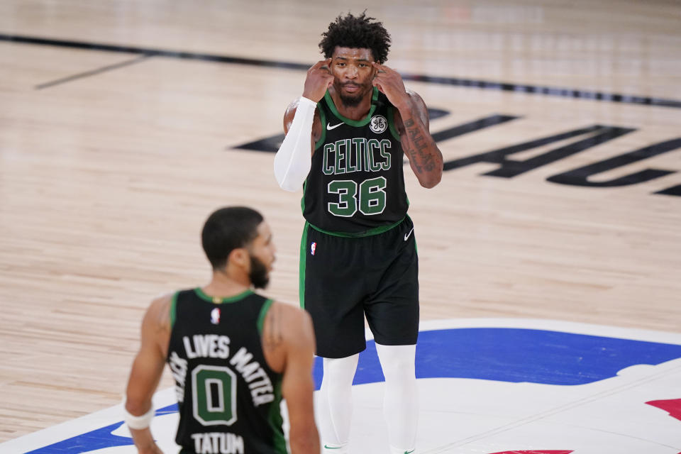 Boston Celtics' Marcus Smart (36) talks with Jayson Tatum (0)nduring the second half of an NBA conference final playoff basketball game against the Miami Heat Friday, Sept. 25, 2020, in Lake Buena Vista, Fla. The Celtics won 121-108. (AP Photo/Mark J. Terrill)