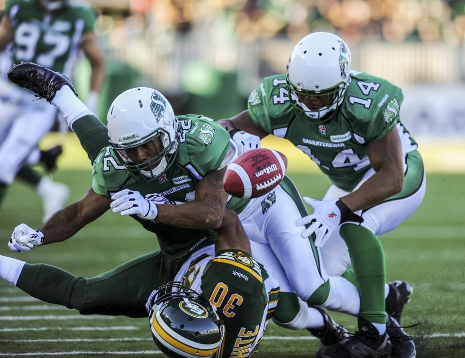 Saskatchewan Roughriders Ferri and Miller bring down Eskimos White during the second half of their CFL football game in Regina, Saskatchewan