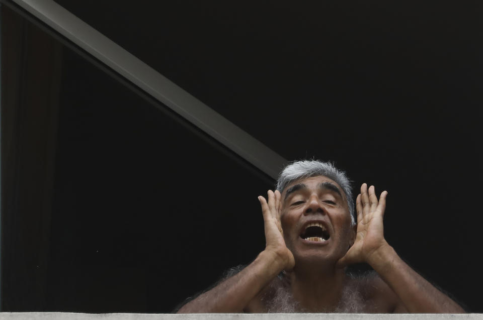 Marcelo Gomez grita a la prensa sobre las pobres condiciones en las que dice vivir en un hotel mientras está en cuarentena impuesta por el gobierno en Buenos Aires, Argentina, el miércoles 1 de abril de 2020. (AP Foto/Natacha Pisarenko)