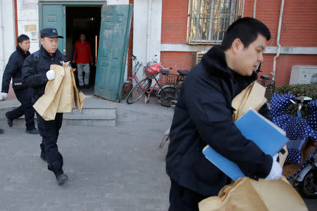 Police carry bags from a primary school that was the scene of a knife attack in Beijing, China, January 8, 2019. REUTERS/Thomas Peter