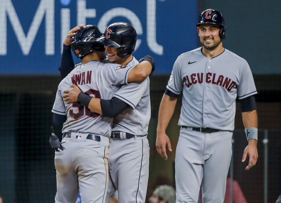 Cleveland Guardians' Steven Kwan, left, Tyler Freeman, center, and Luke Maile, right, celebrate after Kwan hit a grand slam during the eighth inning of a baseball game against the Texas Rangers in Arlington, Texas, Sunday, Sept. 25, 2022. (AP Photo/Gareth Patterson)