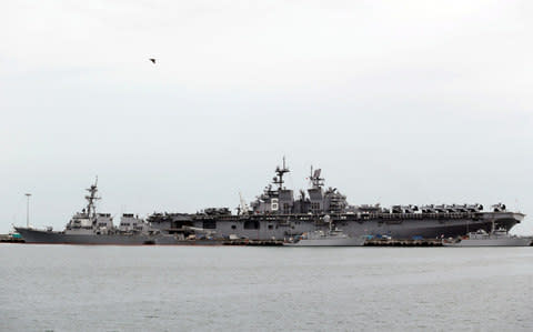 The damaged USS John McCain (L) and the USS America are docked at Changi Naval Base in Singapore  - Credit: REUTERS