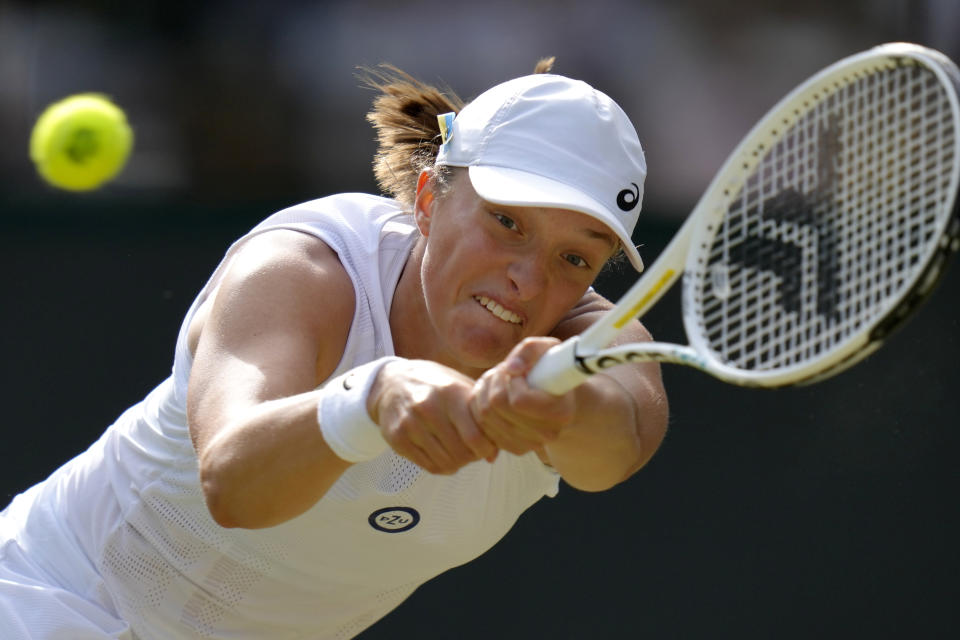 FILE - Poland's Iga Swiatek returns the ball to France's Alize Cornet during a third round women's singles match on day six of the Wimbledon tennis championships in London, Saturday, July 2, 2022. Swiatek is just 5-3 at the All England Club, compared to her 28-2 mark at Roland Garros. (AP Photo/Kirsty Wigglesworth, File)