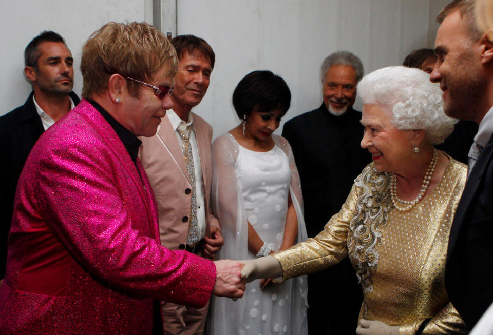 En 1995, la reine Elizabeth II reconnaît le talent d'Elton John comme légende vivante de la musique, et le fait commandeur de l’Ordre de l’Empire britannique (le troisième rang le plus élevé de l’Ordre de la chevalerie britannique). Puis en 1998, sa fan couronnée l’élève au rang de chevalier. Il est donc d’usage de nommer celui qui est né sous le nom de Reginald Kenneth Dwight : Sir Elton Hercules John. <em>©Getty Images</em>