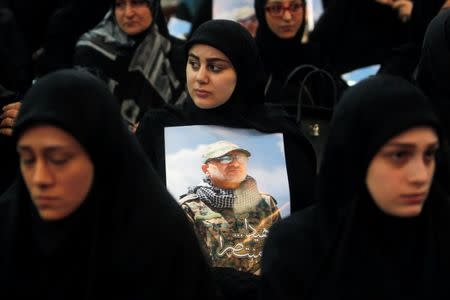 Women carry pictures of Hezbollah commander Mustafa Badreddine, who was killed in an attack in Syria, during a ceremony marking a year after his death in Beirut's southern suburbs, Lebanon May 11, 2017. REUTERS/Aziz Taher