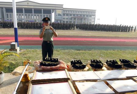 A Chinese army advisor uses a mobile phone to take pictures during a graduation ceremony at Army Institute in Kampong Speu province March 12, 2015. REUTERS/Samrang Pring