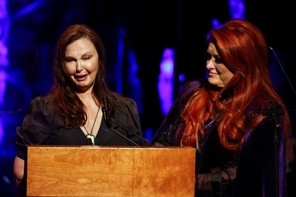 Ashley Judd, left, cries as she speaks while sister Wynonna Judd listens during the Country Music Hall of Fame Medallion Ceremony Sunday, May 1, 2022, in Nashville, Tenn. (Photo by Wade Payne/Invision/AP) ORG XMIT: CAJS126