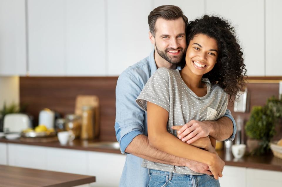 Two people hugging in a kitchen.