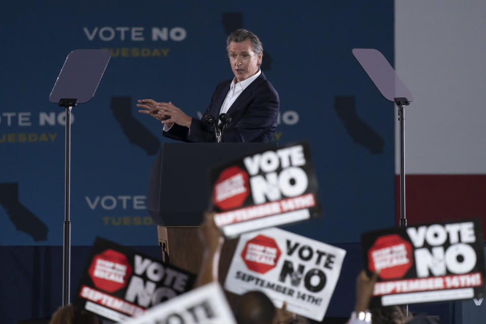 Supporters hold up signs as California Gov. Gavin Newsom speaks at a rally ahead of the California gubernatorial recall election Monday, Sept. 13, 2021, in Long Beach, Calif. (AP Photo/Jae C. Hong)