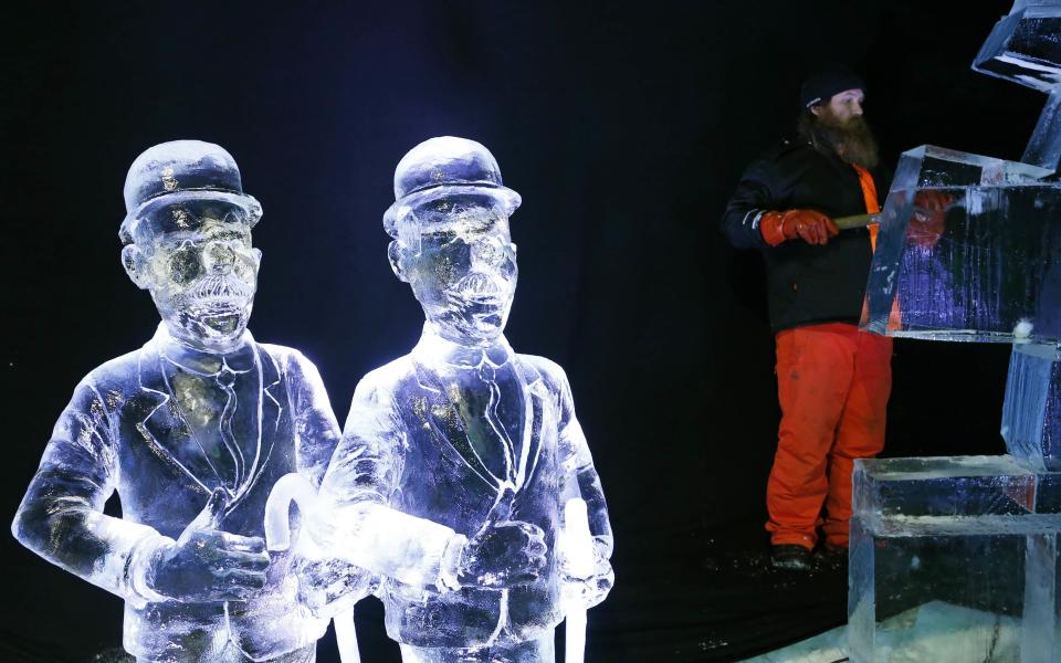 Sculptor Juuso Partanen of Finland carves a sculpture near other sculptures based on characters of comic strips at the Brussels Ice Magic Festival December 17, 2013. Some 20 artists from all over the world made sculptures out of 420 tonnes of ice. The festival will open on December 20 and will end on February 9, 2014. REUTERS/Francois Lenoir (BELGIUM - Tags: ENTERTAINMENT SOCIETY)