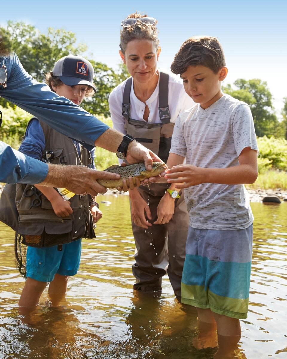 Family Holding Fish Caught From Fly Fishing