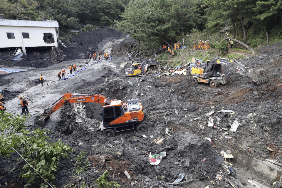 Firefighters search for missing people in an area struck by a landslide after heavy rain in Busan, South Korea, Thursday, Oct. 3, 2019. A powerful typhoon has lashed southern South Korea, leaving nine people dead and five others missing. (Jo Jung-ho/Yonhap via AP)