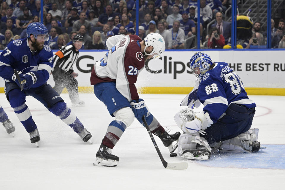 Tampa Bay Lightning goaltender Andrei Vasilevskiy (88) gloves a shot by Colorado Avalanche right wing Logan O'Connor (25) during overtime of Game 4 of the NHL hockey Stanley Cup Finals on Wednesday, June 22, 2022, in Tampa, Fla. (AP Photo/Phelan Ebenhack)