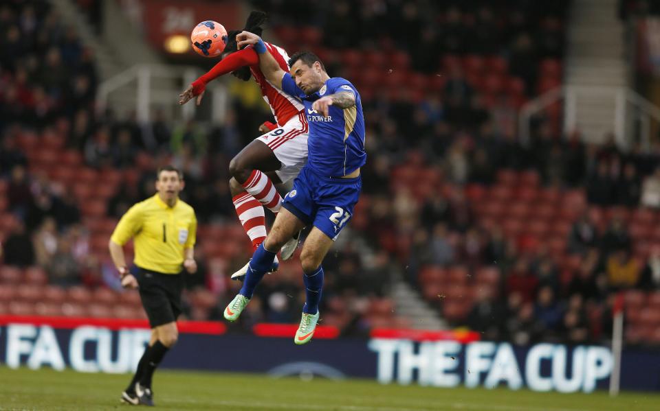 Leicester City's Marcin Wasilewski (R) challenges Stoke City's Kenwyne Jones during their English FA Cup third round soccer match at the Britannia stadium in Stoke-on-Trent, central England January 4, 2014. REUTERS/Stefan Wermuth (BRITAIN - Tags: SPORT SOCCER TPX IMAGES OF THE DAY)