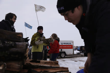 Campers unload donated wood inside of the Oceti Sakowin camp as "water protectors" continue to demonstrate against plans to pass the Dakota Access pipeline near the Standing Rock Indian Reservation, near Cannon Ball, North Dakota, U.S., December 2, 2016. REUTERS/Lucas Jackson