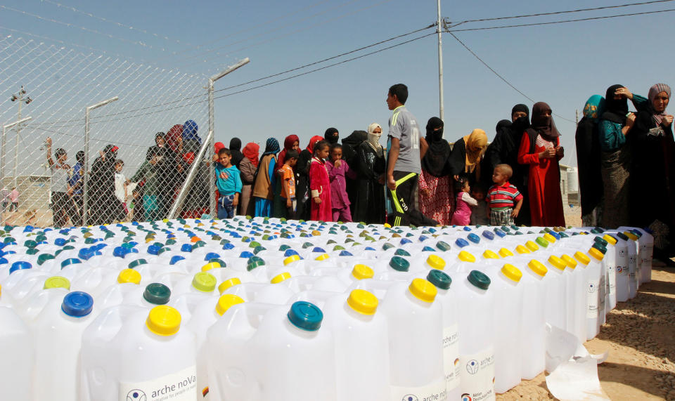 Displaced people receive aid at a camp in Daquq