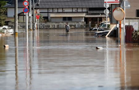 A local resident makes his way in a flooded area in Mabi town in Kurashiki, Okayama Prefecture, Japan, July 8, 2018. REUTERS/Issei Kato