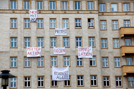 Banners hang from an apartment block on Karl Marx Allee in Berlin, Germany, November 20, 2018, to protest against plans to sell flats on a boulevard of imposing Stalinist architecture that was one of the flagship building projects of the former German Democratic Republic after World War Two. Banners read "capitalist avenue" and "tenants action against speculation". REUTERS/Joachim Herrmann