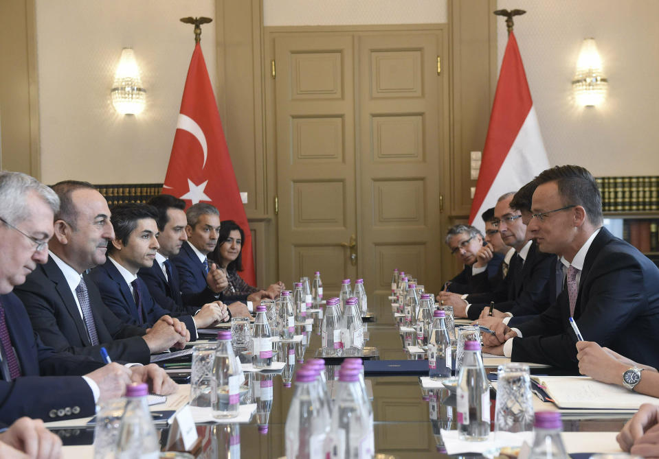 Hungarian Minister of Foreign Affairs and Trade Peter Szijjarto, right, and Turkish Foreign Minister Mevlut Cavusoglu, second left, sit with their delegations during a meeting at the Ministry of Foreign Affairs and Trade in Budapest, Hungary, Friday, May 3, 2019. (Noemi Bruzak/MTI via AP)