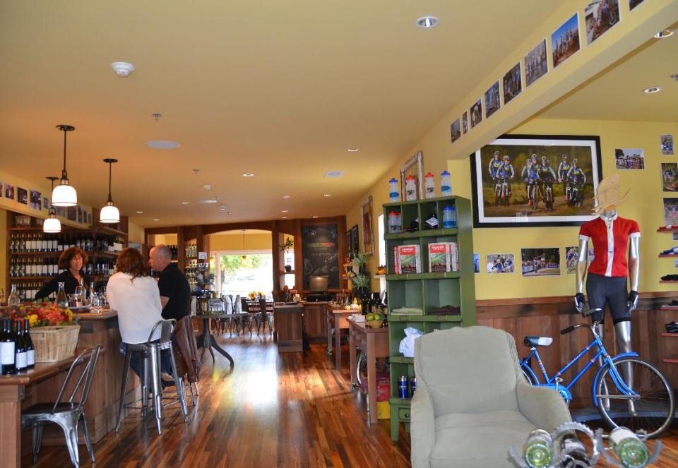 This October 2011 photo shows visitors sampling both wine and cycling memorabilia during a stop at Velo Vino Napa Valley in St. Helena, Calif., founded by the family that makes Clif Bars and Clif Family wines. Velo Vino offers wine tastings and wines and speciality foods for sale, as well as bike tours and cycling events. (AP Photo/Paula Froke)