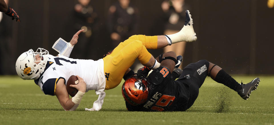 Oklahoma State linebacker Justin Phillips (19) sacks West Virginia quarterback Will Grier (7) during the first half of an NCAA college football game in Stillwater, Okla., Saturday, Nov. 17, 2018. (AP Photo/Brody Schmidt)
