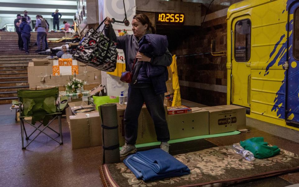 Kharkiv resident Tatiana, who has been living in an underground metro station for more than two months, packs her belongings to move home  - Getty Images