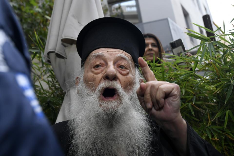 A protesting Orthodox Priest shouts against the visit of Pope Francis at the Archbishopric of Greece in Athens, Saturday, Dec. 4, 2021. Pope Francis warned Saturday that the "easy answers" of populism and authoritarianism threaten democracy in Europe and called for fresh dedication to promoting the common good. (AP Photo/Michael Varaklas)