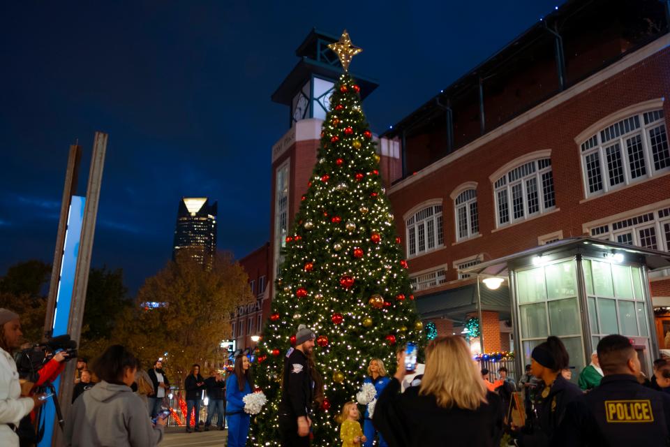 People look at a Christmas tree during a tree lighting ceremony on Thursday in Bricktown.