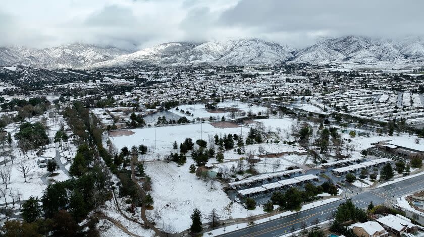 Yucaipa, CA - February 23: Youth revel in the rare snowfall in Yucaipa with a view of the San Bernardino County mountains, as the National Weather Service issues its first-ever blizzard warning for the mountains, following a similar warning for LA and Ventura counties. Photo taken at Yucaipa Community Park in Yucaipa Thursday, Feb. 23, 2023. The National Weather Service issued its first-ever blizzard warning for the San Bernardino County mountains, following a similar warning for Los Angeles and Ventura counties. Southern California has only gotten a taste of the powerful winter storm system that forecasters say will bring an extended period of cold temperatures, high winds and snow, prompting the region's first blizzard warning on record. (Allen J. Schaben / Los Angeles Times)