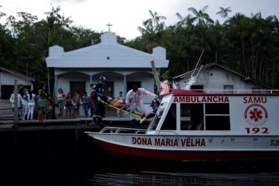 En la imagen, el doctor Jorge Hernandez, de 35 años, y su equipo trasladan a Maria Angela, una mujer de 56 que dio positivo por Covid-19, desde su domicilio en el municipio brasileño de Portel, en la isla de Marajó, hasta un barco ambulancia para trasladarla al hospital. (Foto: Uesley Marcelino / Reuters).