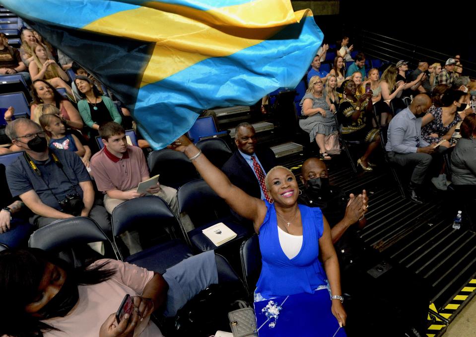 Valderine Evans of the Bahamas, mother of University of Illinois Springfield graduate Antone Evans Jr., waves the flag of the Bahamas on Saturday during the university's 51st annual commencement ceremony at the BOS Center. Evans Jr., who is from Nassau, Bahamas, was one of the graduates who spoke during the ceremony. He graduated with a master's degree in computer science. [Thomas J. Turney/The State Journal-Register]