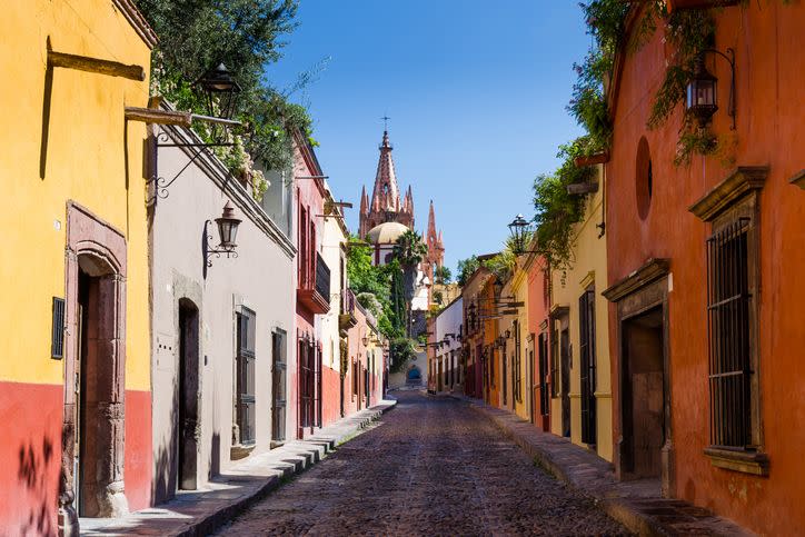 famous aldama street with fountain and dome of cathedral, san miguel, mexico