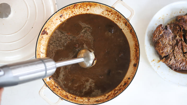 immersion blender in a pot of broth