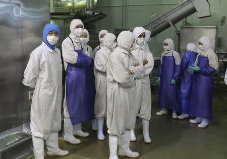 Employees stand during a seizure conducted by officers from the Shanghai Food and Drug Administration, at the Husi Food factory in Shanghai, July 20, 2014. REUTERS/Stringer