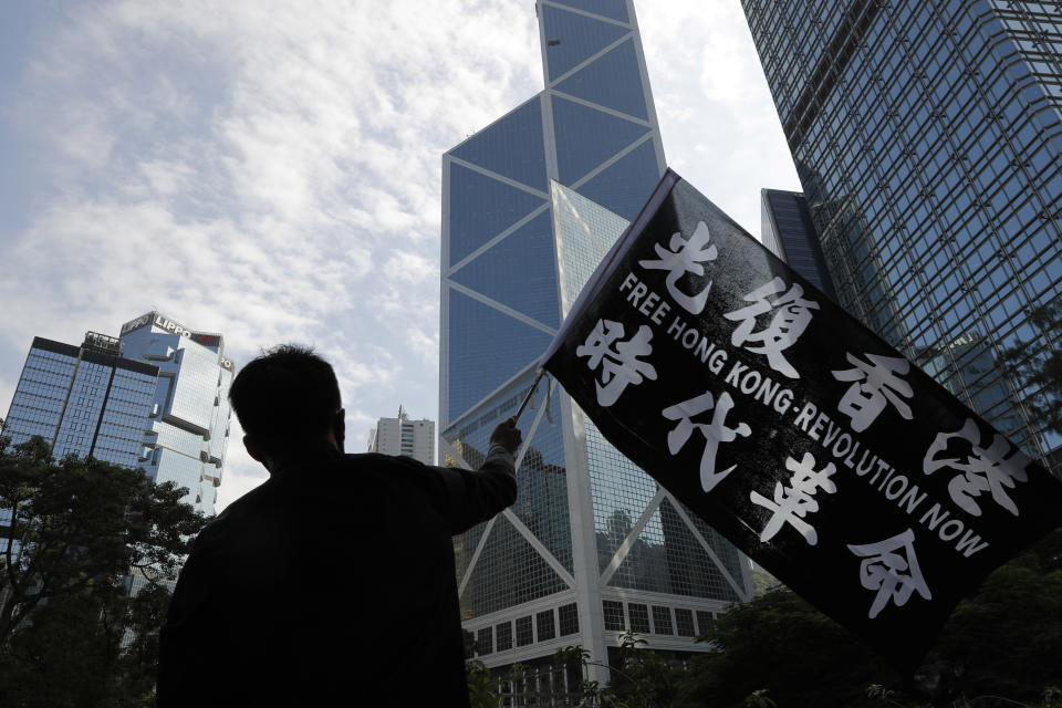 A pro-democracy supporter waves a flag during a rally by the advertising industry in Hong Kong on Monday, Dec. 2, 2019. Thousands of people took to Hong Kong's streets Sunday in a new wave of pro-democracy protests, but police fired tear gas after some demonstrators hurled bricks and smoke bombs, breaking a rare pause in violence that has persisted during the six-month-long movement. (AP Photo/Vincent Thian)