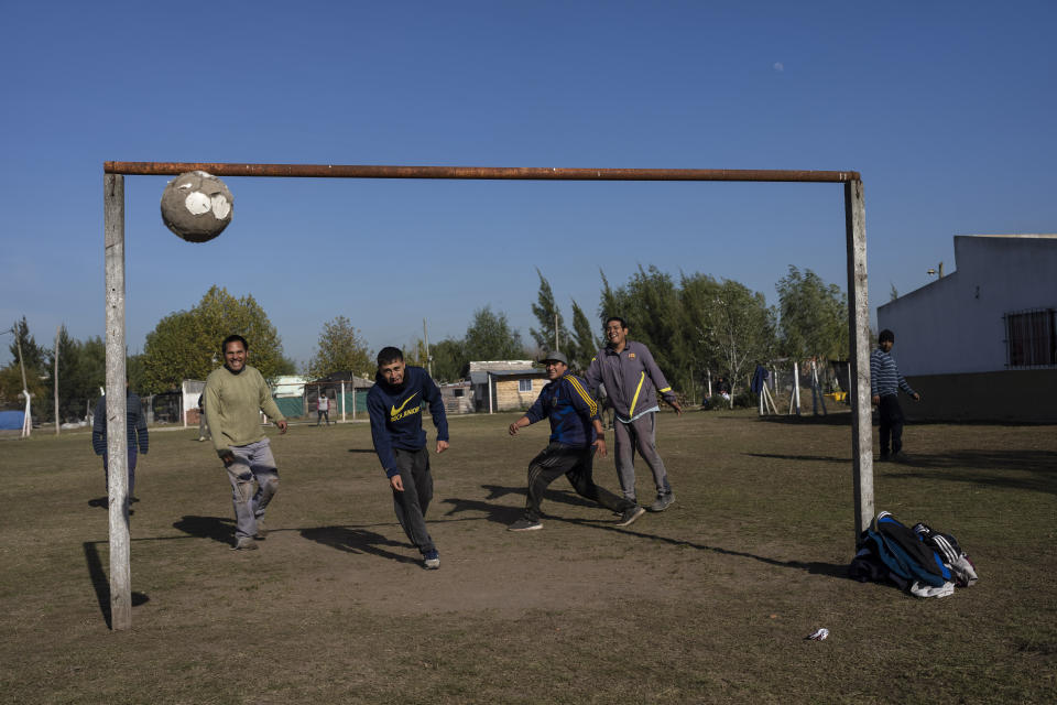 Members of the Frente de Organizaciones en Lucha, FOL, social organization, play a pickup soccer game during a work break in the impoverished "El Peligro" neighborhood, south of Buenos Aires, Argentina, Friday, May 20, 2022. Social organizations such as the FOL do not simply provide food, they also have strong ties to political leaders which facilitates receiving subsidies and access to work programs. (AP Photo/Rodrigo Abd)