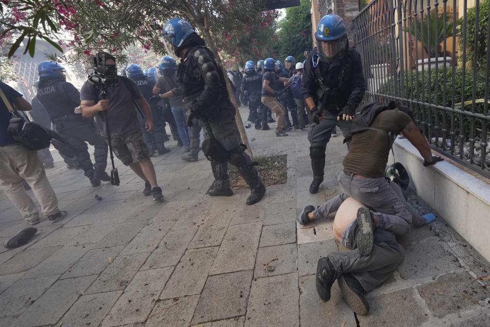 EDS NOTE NUDITY: A demonstrator is blocked by a police officer during clashes broke out between demonstrators and Italian Policemen in riot gears on the occasion of a protest against the G20 Economy and Finance ministers and Central bank governors' meeting in Venice, Italy, Saturday, July 10, 2021. (AP Photo/Luca Bruno)