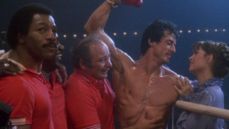 Rocky Balboa stands in victory at the end of Rocky III