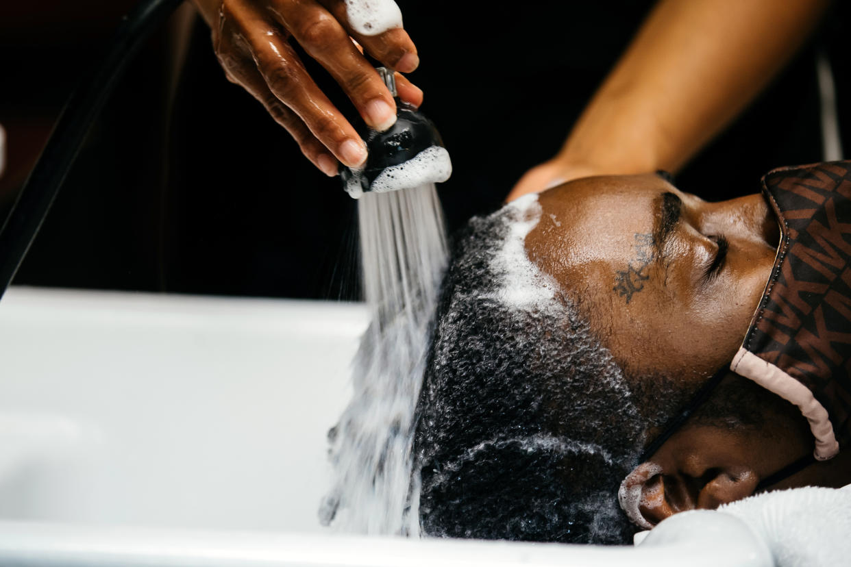 Nina Arthur, propietaria de Nina's Hair Care en Flint, Míchigan, lava el cabello de una clienta el 1.° de mayo de 2021. (Allison Farrand/The New York Times)