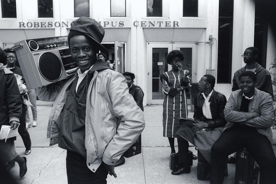 Teen boy in the '80s carrying a boom box on his shoulder