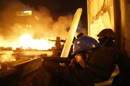 Anti-government protesters aim their weapons during clashes with riot police at Independence Square in Kiev February 18, 2014. REUTERS/Vasily Fedosenko