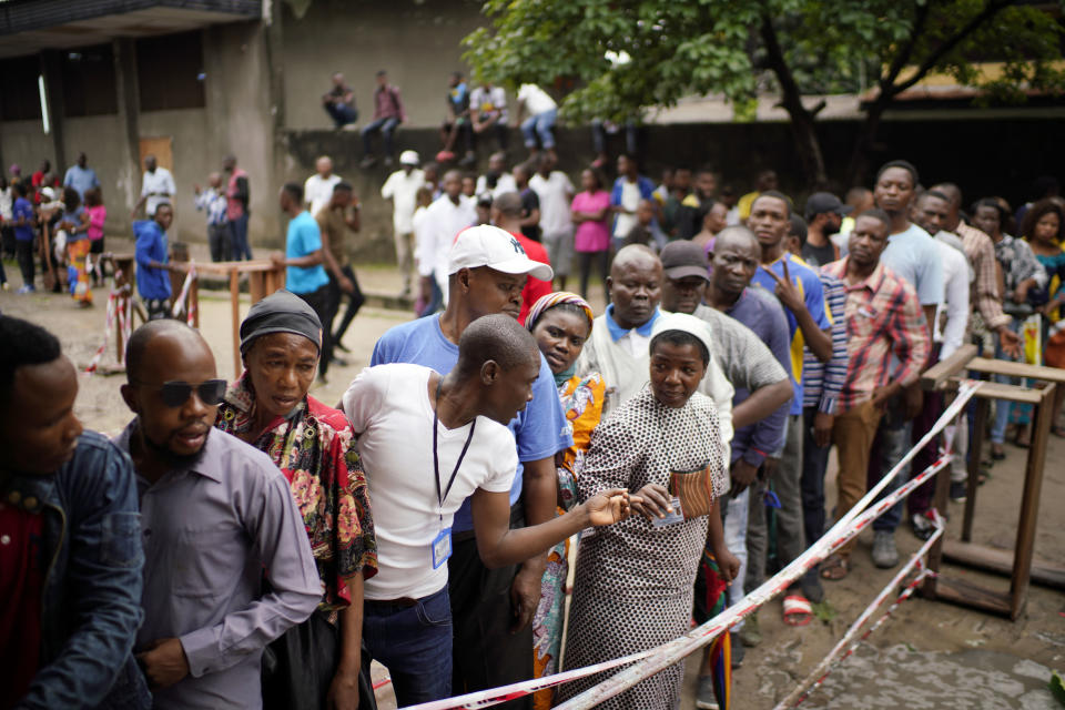 Congolese voters who have been waiting at the St. Raphael school in the Limete district of Kinshasa Sunday Dec. 30, 2018, line up to vote after the voters listings were finally posted five hours after the official start of voting. Some forty million voters are registered for a presidential race plagued by years of delay and persistent rumors of lack of preparation. (AP Photo/Jerome Delay)